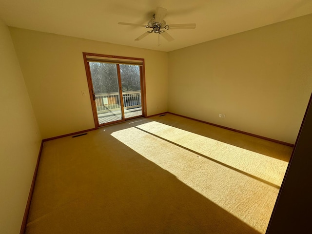 carpeted spare room featuring ceiling fan