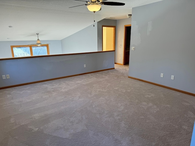 carpeted empty room with a textured ceiling, ceiling fan, and lofted ceiling