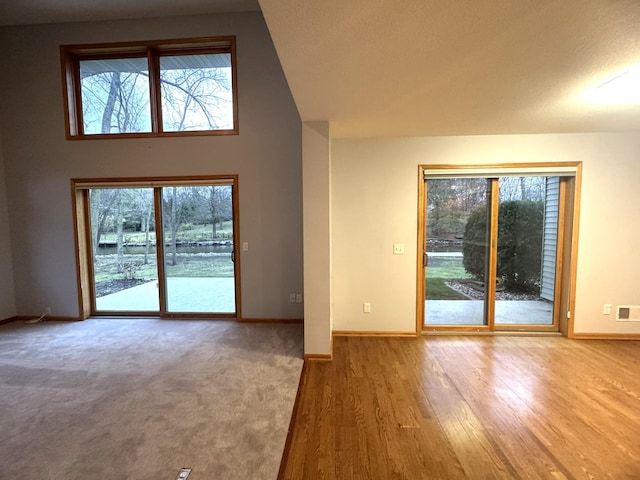 unfurnished living room with a wealth of natural light, a textured ceiling, and hardwood / wood-style flooring