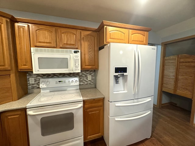 kitchen with dark hardwood / wood-style flooring, white appliances, and backsplash