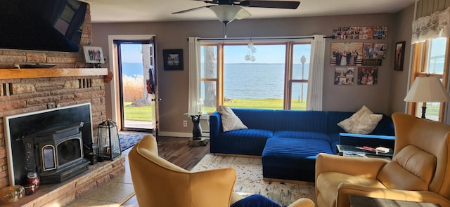 living room with a water view, light hardwood / wood-style flooring, a wealth of natural light, and ceiling fan