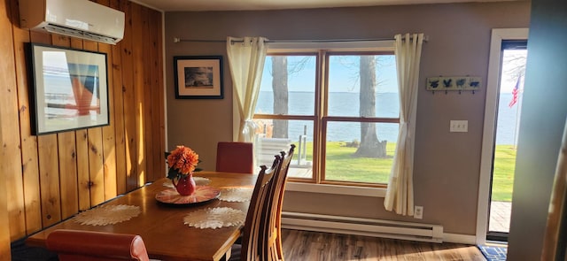 dining area featuring a wealth of natural light, a water view, a wall unit AC, and a baseboard heating unit