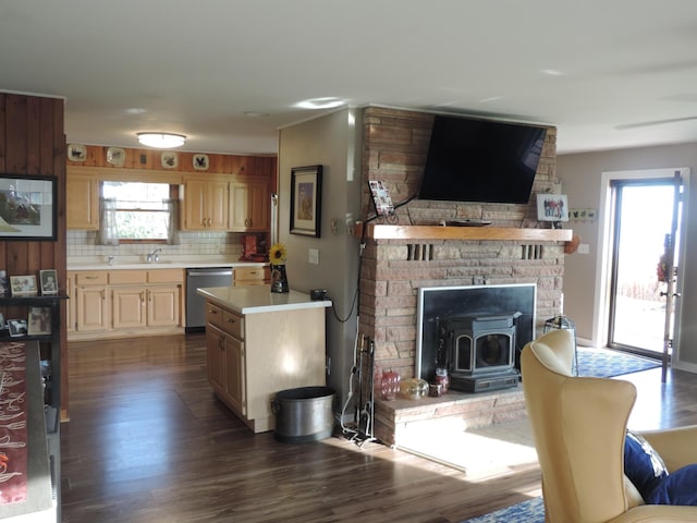 kitchen with decorative backsplash, a wood stove, stainless steel dishwasher, and dark wood-type flooring