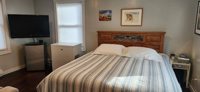 bedroom featuring refrigerator, stainless steel refrigerator, and dark wood-type flooring