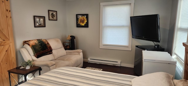 living area featuring hardwood / wood-style flooring and a baseboard heating unit