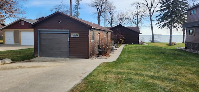 garage featuring a lawn and a water view