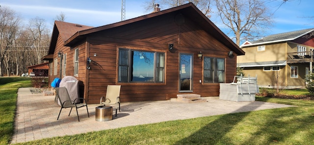 rear view of house featuring a patio area and a lawn