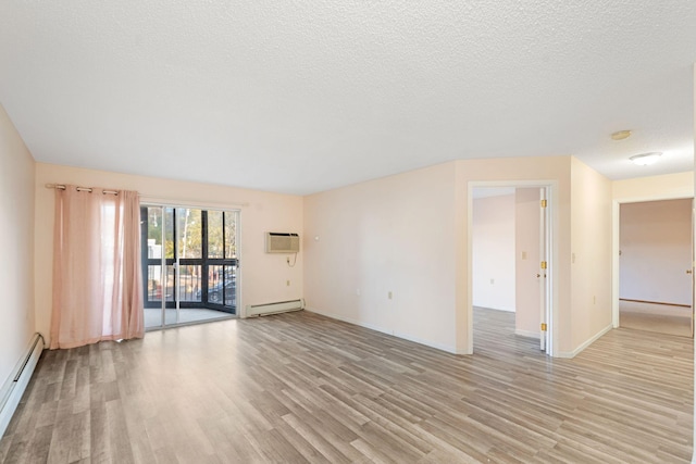 empty room with a wall mounted air conditioner, light hardwood / wood-style floors, a textured ceiling, and a baseboard heating unit