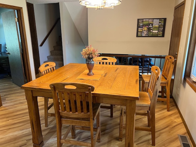 dining area featuring a chandelier and light hardwood / wood-style floors