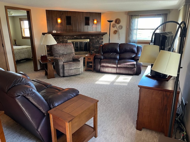 living room with light carpet, a textured ceiling, and a brick fireplace