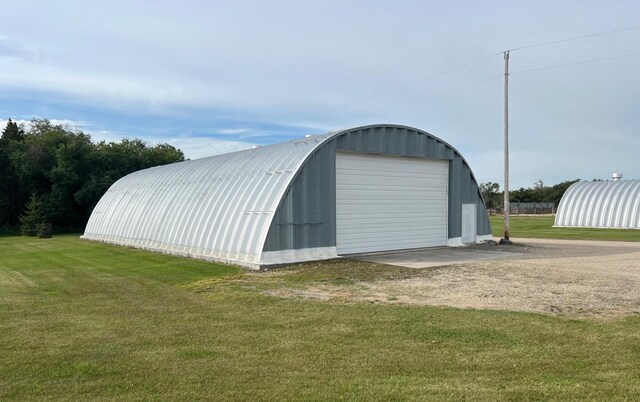 view of outdoor structure featuring a yard and a garage