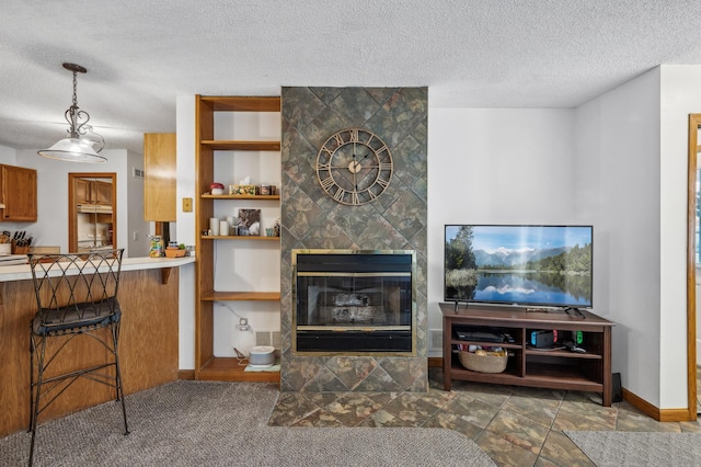 living room with a textured ceiling, a fireplace, and built in shelves