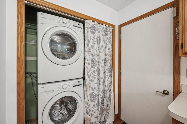 clothes washing area with stacked washer / dryer