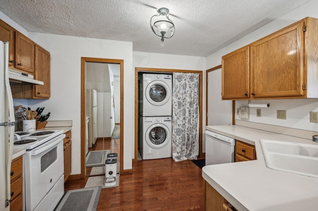 kitchen with stacked washer and dryer, white appliances, sink, a textured ceiling, and dark hardwood / wood-style flooring