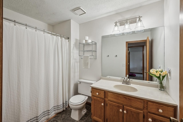 bathroom with vanity, tile patterned flooring, a textured ceiling, and toilet