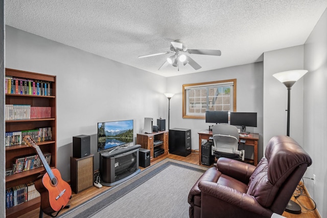 office space featuring a textured ceiling, ceiling fan, and light wood-type flooring