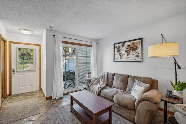 living room featuring a textured ceiling, a wealth of natural light, and baseboards