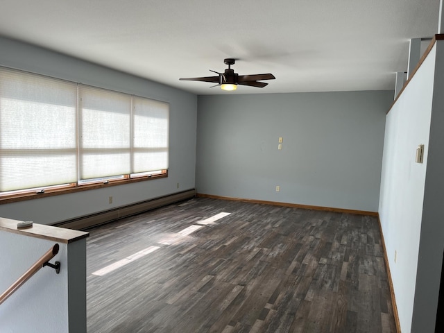 spare room featuring ceiling fan, dark hardwood / wood-style floors, and a baseboard heating unit