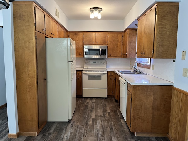 kitchen with sink, dark hardwood / wood-style floors, and white appliances