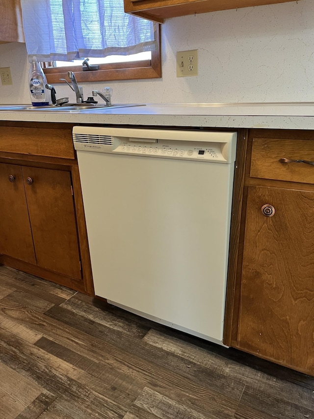 kitchen with white dishwasher, dark hardwood / wood-style flooring, and sink