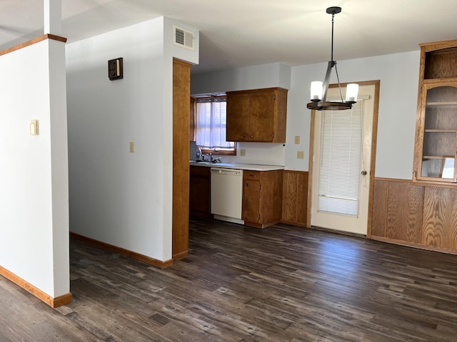 kitchen with dark hardwood / wood-style flooring, dishwasher, pendant lighting, and an inviting chandelier