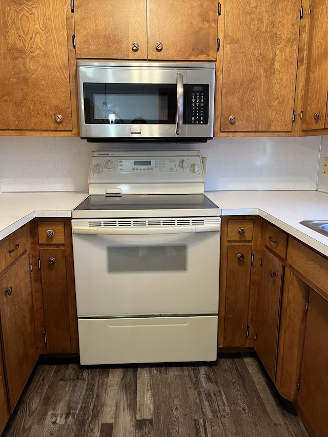 kitchen with electric range and dark wood-type flooring