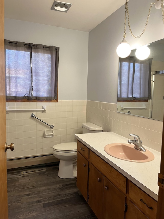 bathroom with vanity, wood-type flooring, tile walls, and toilet