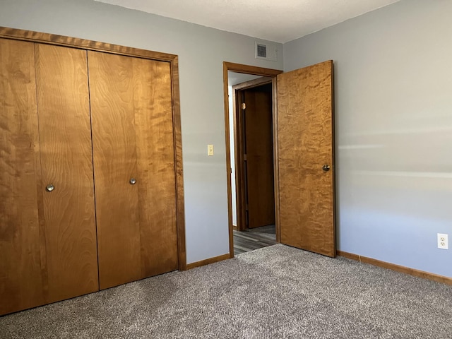 unfurnished bedroom featuring a closet and dark colored carpet