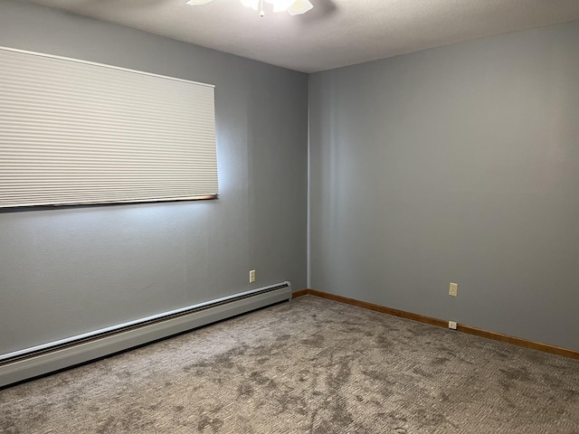 spare room with carpet flooring, ceiling fan, and a baseboard heating unit