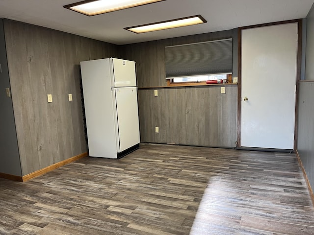 interior space featuring dark hardwood / wood-style floors and wooden walls