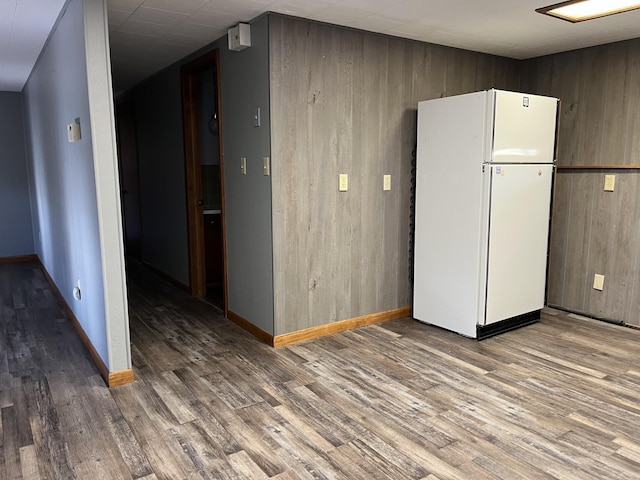 unfurnished room featuring wood-type flooring and wooden walls