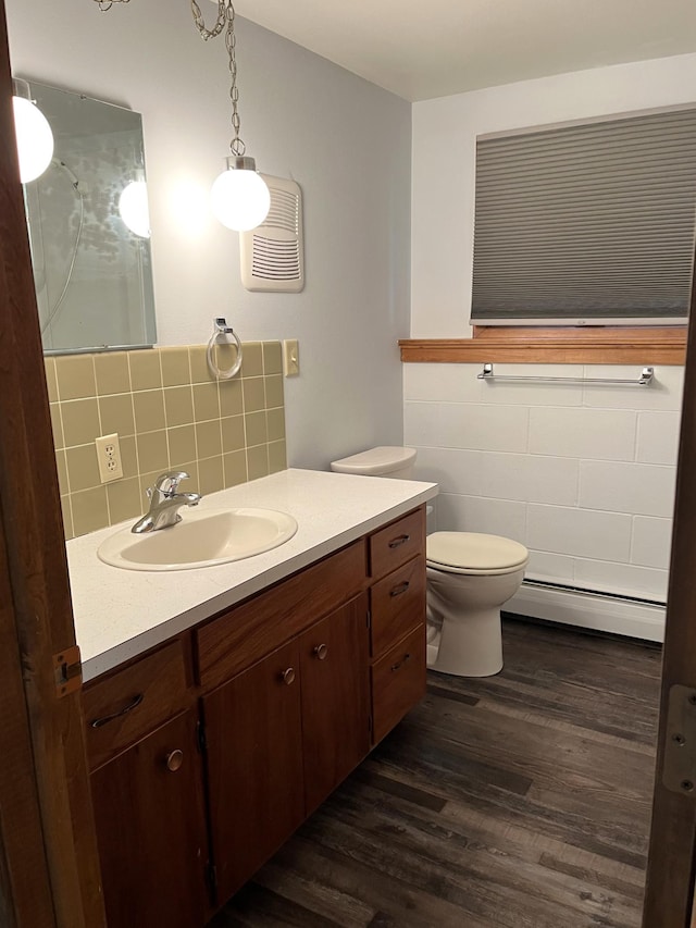 bathroom featuring a baseboard radiator, wood-type flooring, toilet, decorative backsplash, and vanity