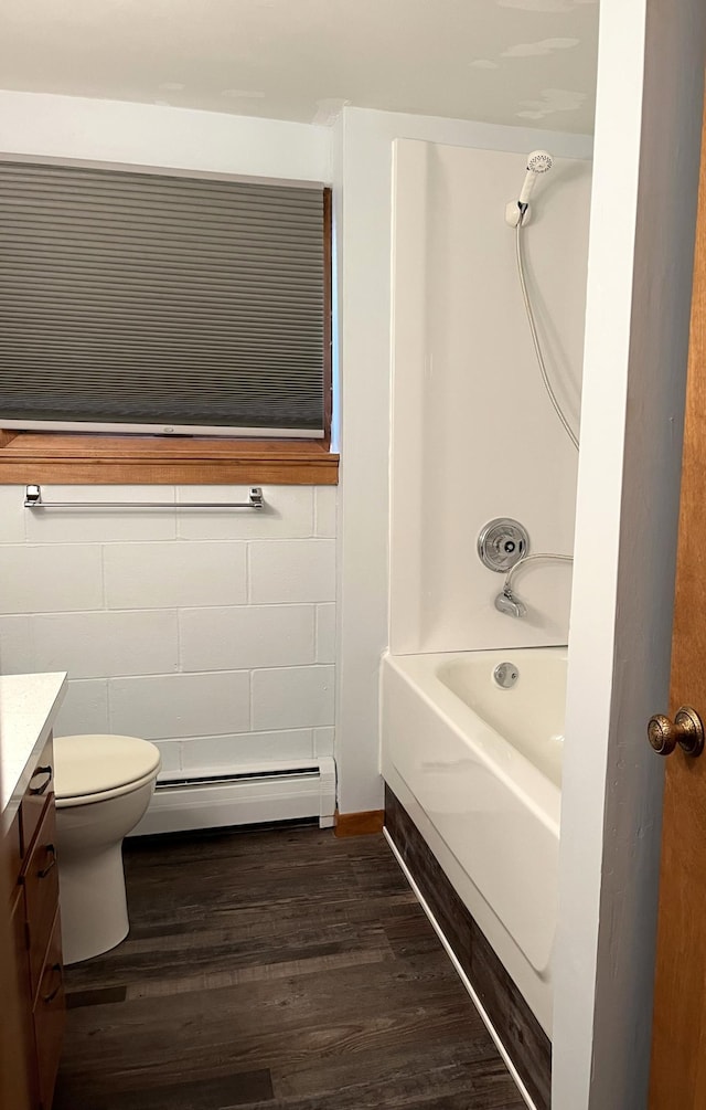 full bathroom featuring vanity, bathing tub / shower combination, a baseboard radiator, hardwood / wood-style flooring, and toilet