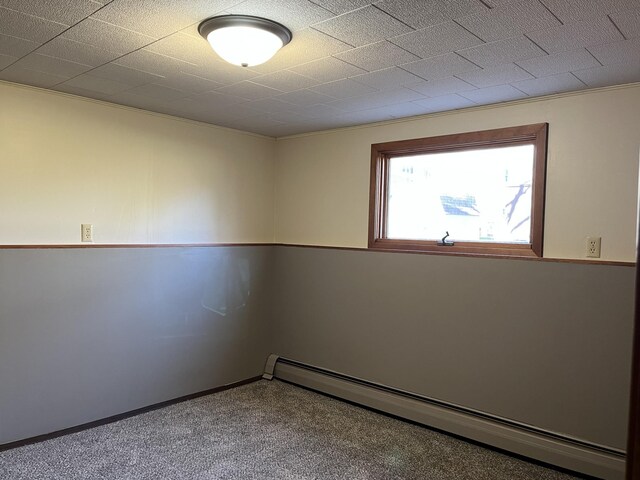 unfurnished room featuring carpet, crown molding, and baseboard heating