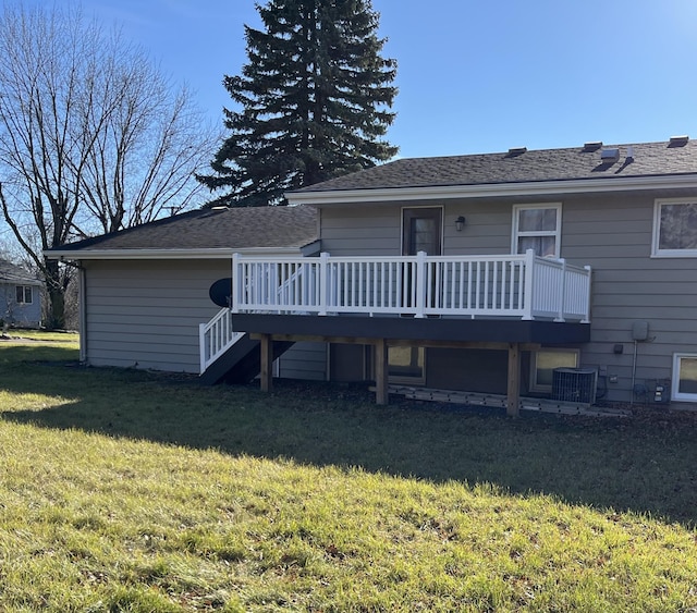 back of house with central AC, a wooden deck, and a lawn