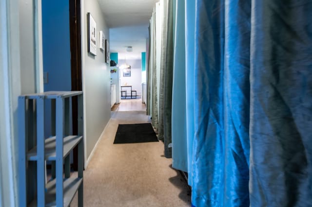 hallway featuring light colored carpet