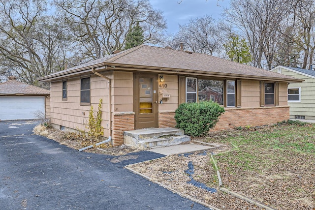 view of front facade featuring a garage and an outbuilding