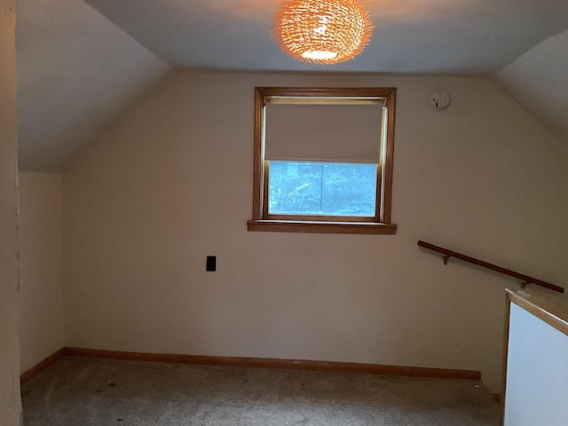 additional living space with carpet flooring and lofted ceiling