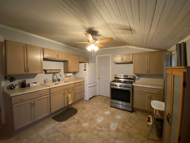 kitchen featuring light brown cabinets, stainless steel gas stove, sink, white fridge, and vaulted ceiling