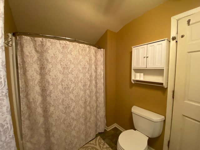 bathroom featuring toilet, tile patterned floors, and lofted ceiling