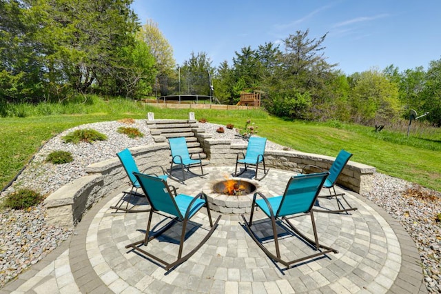 view of patio with a trampoline and an outdoor fire pit