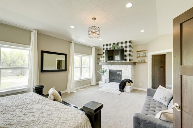 carpeted bedroom featuring a fireplace, vaulted ceiling, and a notable chandelier