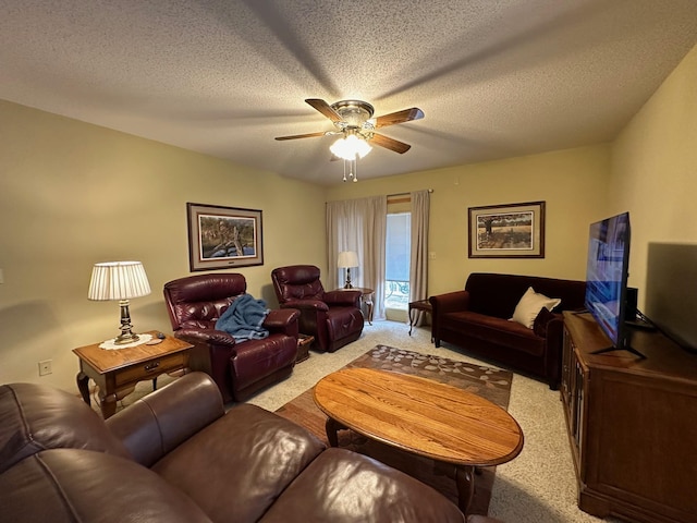 living area featuring a textured ceiling, light colored carpet, and ceiling fan