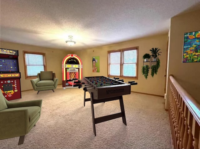 recreation room featuring a textured ceiling, a wealth of natural light, and light carpet