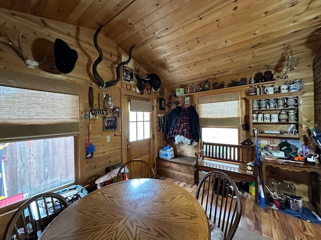 dining area featuring wooden walls, wooden ceiling, lofted ceiling, and wood finished floors