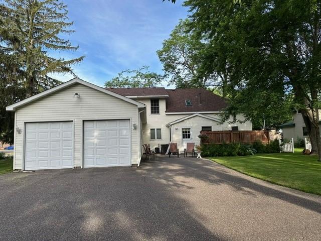 view of front of home featuring aphalt driveway, a garage, and a front lawn