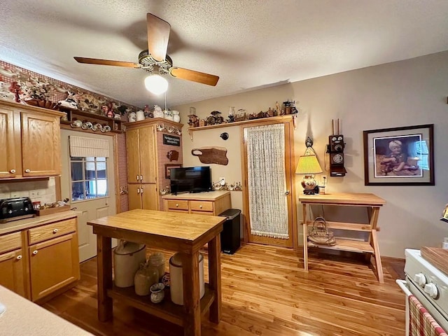 kitchen with wood counters, a textured ceiling, light wood-style floors, and a ceiling fan