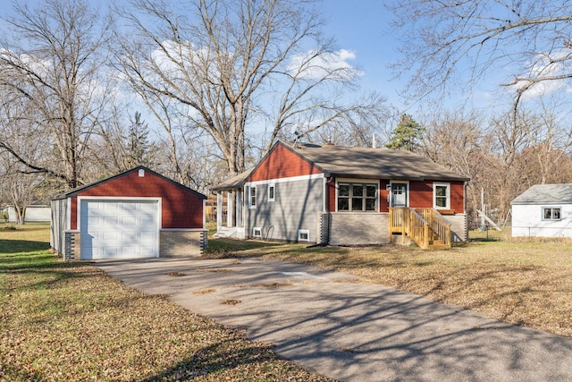 view of front of house featuring an outbuilding, a garage, and a front lawn