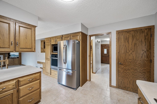 kitchen featuring stainless steel appliances and a textured ceiling