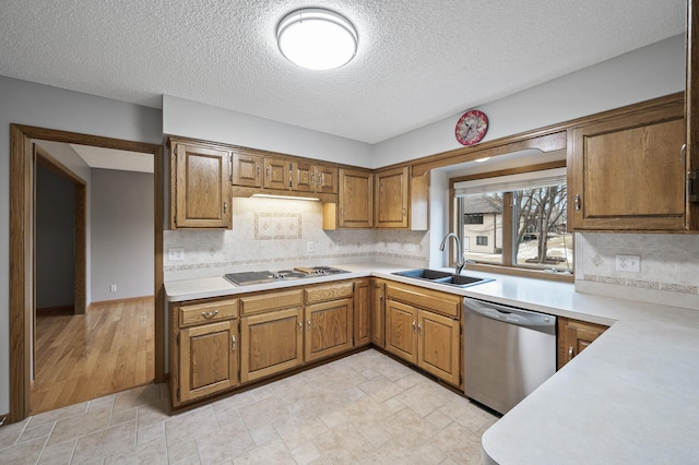 kitchen featuring sink, decorative backsplash, gas cooktop, and dishwasher